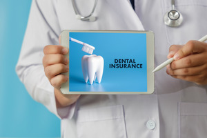 Dentist holding a tablet that says “Dental Insurance”